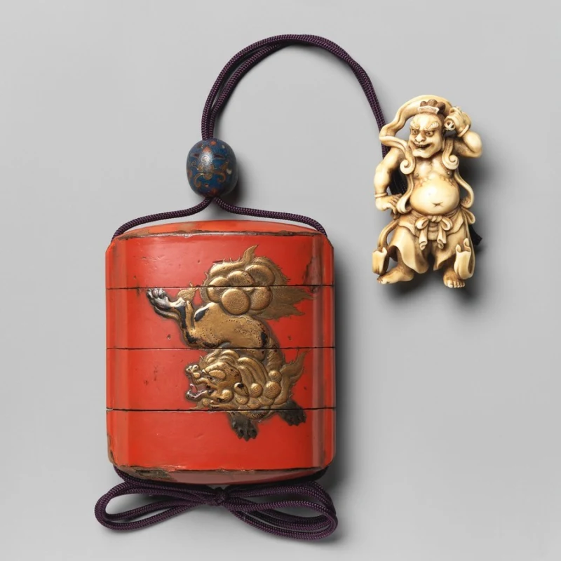 Inro japonés lacado en rojo con su cordón y netsuke, siglo XVII. The Metropolitan Museum of Art, dominio público