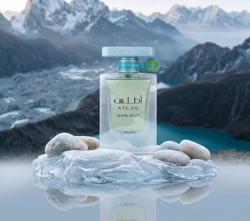 Frasco de Lattafa Atlas Glacial Valley sobre un bloque de hielo con piedras, ante un valle glaciar con montañas nevadas (imagen de Lattafa)