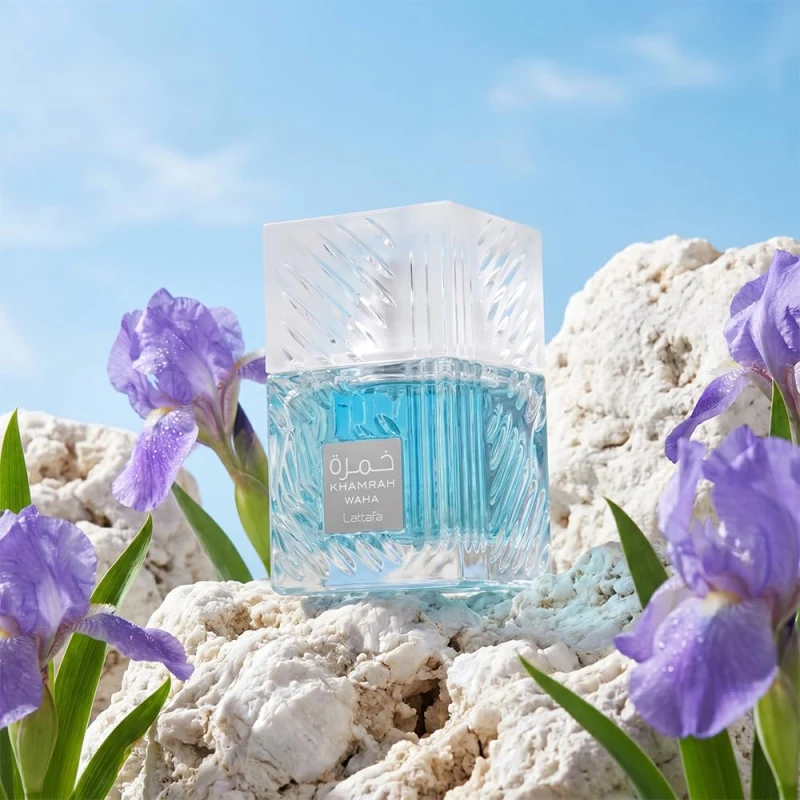 Frasco de cristal azul de Lattafa Khamrah Waha entre rocas blancas e iris