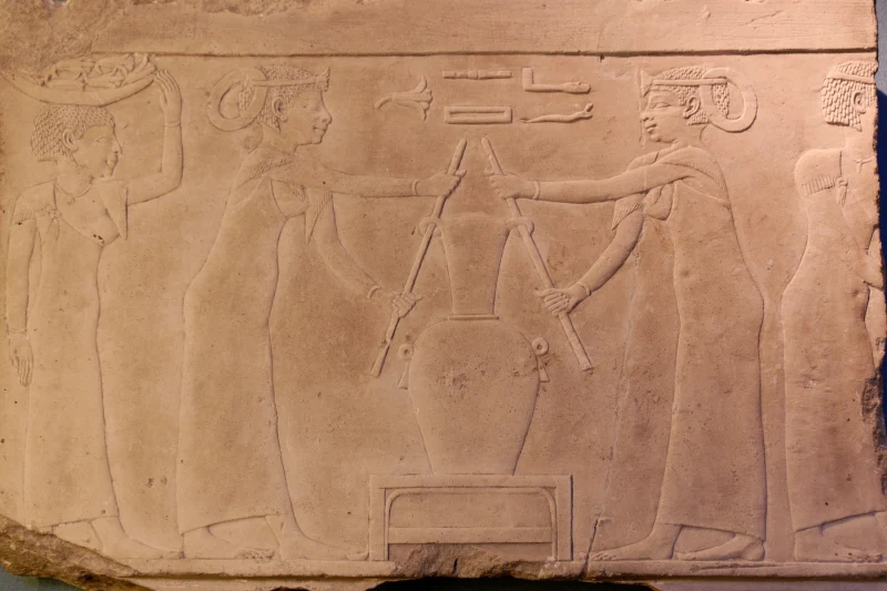 Relieve egipcio del Museo del Louvre: mujeres retorciendo un saco de flores para extraer el perfume de lirio